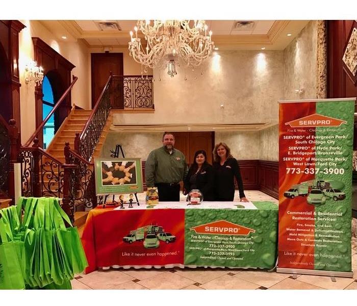 Three SERVPRO employees standing with SERVPRO banners