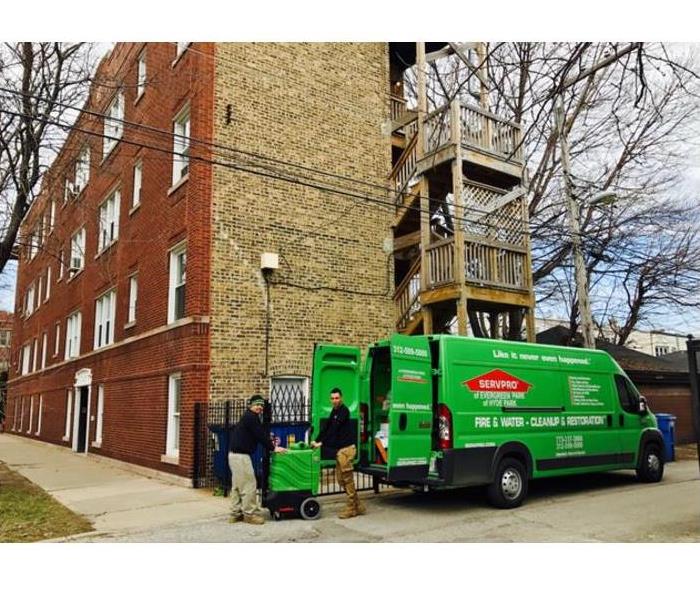 SERVPRO vehicle and employees standing in front of a building