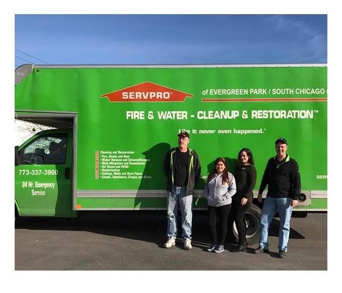 SERVPRO employees standing in front of a SERVPRO vehicle